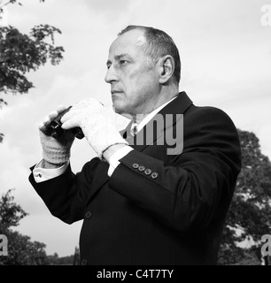 Altmodische Tic tac Mann mit Fernglas bei den Pferderennen. Stockfoto