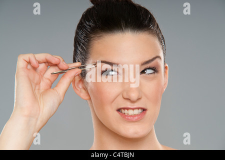 Frau zupfen Augenbrauen Stockfoto