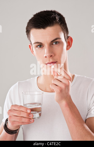 Yougn Mann Einnahme Pille Stockfoto
