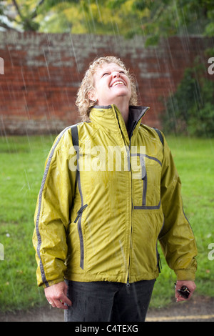 Attraktive mittlere gealterte Frau genießen im Regen stehen Stockfoto