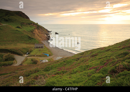 Untergehende Sonne im Millook Haven, angesehen vom Küstenweg, North Cornwall, England, UK Stockfoto