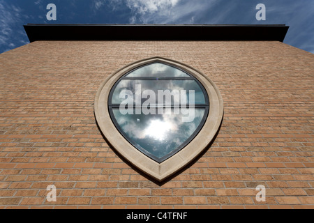 Moderne Glasfenster in einer Elipse Form auf der Außenseite einer Kirche Stockfoto