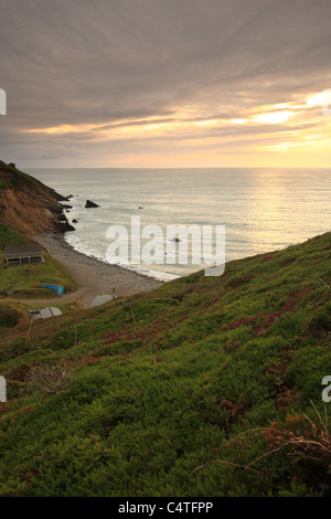 Untergehende Sonne im Millook Haven, angesehen vom Küstenweg, North Cornwall, England, UK Stockfoto