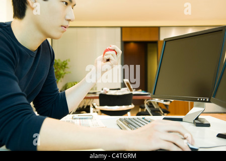 Büroangestellte mit Computer, Stress-Ball mit einer Hand drückte Stockfoto