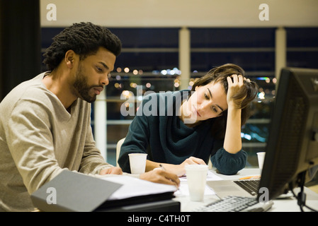 Kolleginnen und Kollegen arbeiten am Projekt zusammen im Büro in der Nacht Stockfoto