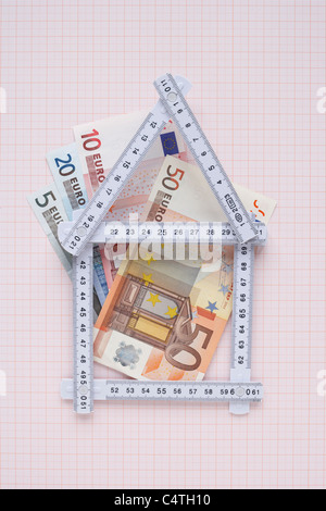 Haus aus erweiterbaren Herrscher und Euro auf Zeichenpapier mit Maßeinteilung Stockfoto