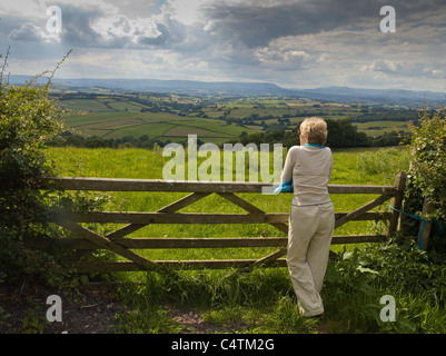 FRAU, STÜTZTE SICH AUF TOR BETRACHTEN BLICK ÜBER USK VALLEY Stockfoto