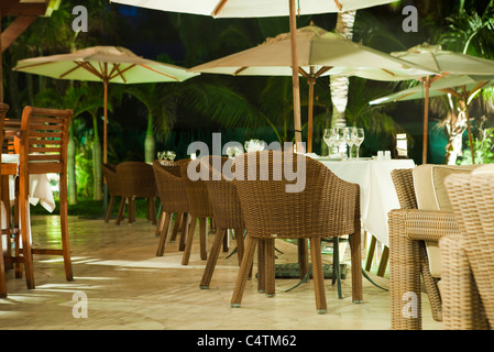 Café im freien beleuchtet bei Nacht, umgeben von Palmen Stockfoto
