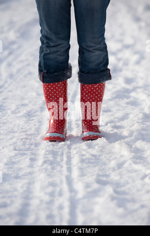 Frau trägt Gummistiefel im Schnee, Salzburg, Österreich Stockfoto