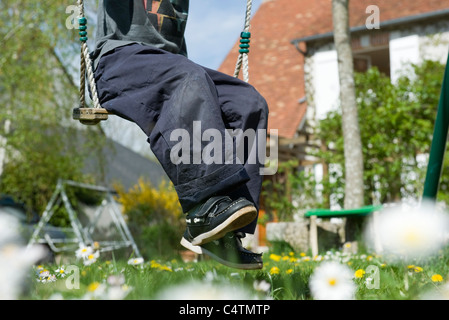 Junge sitzt auf Swing, niedrige Abschnitt Stockfoto