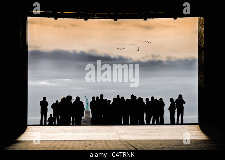 GRUPPE-MENGE IN DER SILHOUETTE IM BOGEN WIE RAHMEN BLICK AUF FREIHEITSSTATUE STEHEN Stockfoto