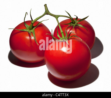 DREI TOMATEN MIT GRÜNEN STAMMT STILLLEBEN Stockfoto