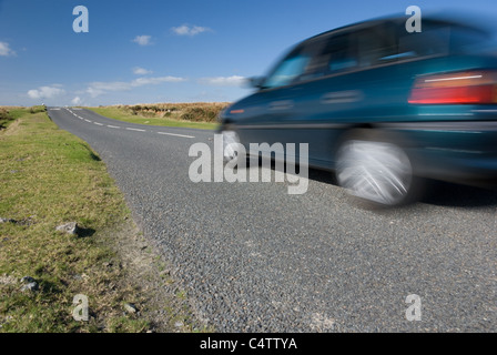 Auto beschleunigt auf leere Straße. Dartmoor, Großbritannien. Stockfoto