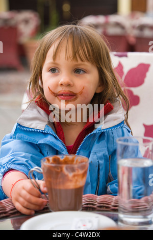 3 Jahre altes Mädchen trinken heißen Schokolade im Café im Freien in Zagreb, Kroatien Stockfoto