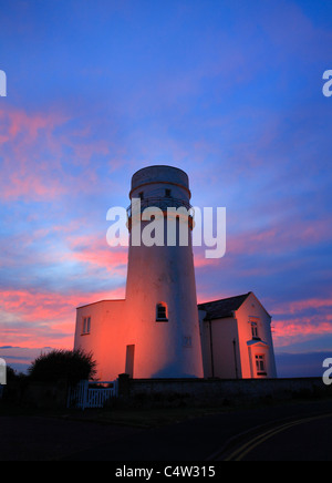 Der Leuchtturm am alten Hunstanton gegen einen farbenfrohen Sonnenuntergang. Stockfoto