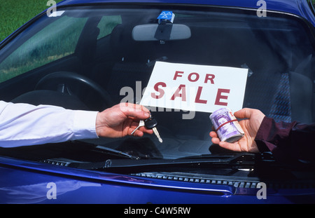 Person, die Bündel Banknoten kaufen Auto von Verkäufer halten Autoschlüssel UK Stockfoto