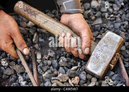 Detail der schmutzigen Hände halten Hammer - Schmied Stockfoto