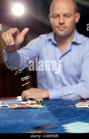 hübscher zuversichtlich Mann werfen Chips Poker zu spielen Stockfoto