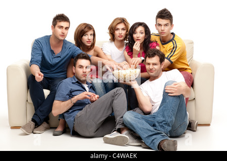 Freunde sitzen auf couch vor dem Fernseher Essen Popcorn Ausdrücke Stockfoto