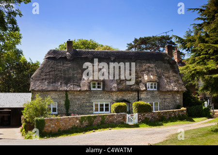 Schönes traditionelles altes Landhaus mit Reetdach an einem sonnigen Sommertag im malerischen Dorf Ashmore, Dorset, England, Großbritannien Stockfoto