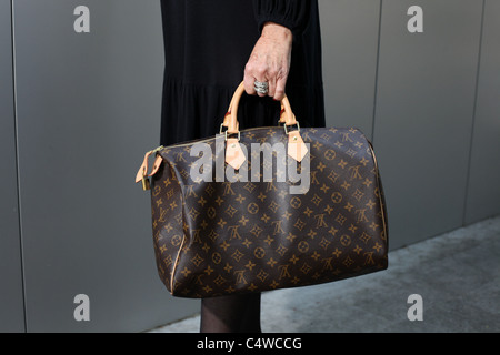 Frau hält eine Louis Vuitton Handtasche. Stockfoto