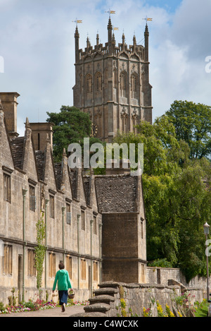 Eine Frau geht vorbei an Armenhäuser in der Nähe von St James Church, Chipping Campden in Worcestershire Cotswolds. UK Stockfoto