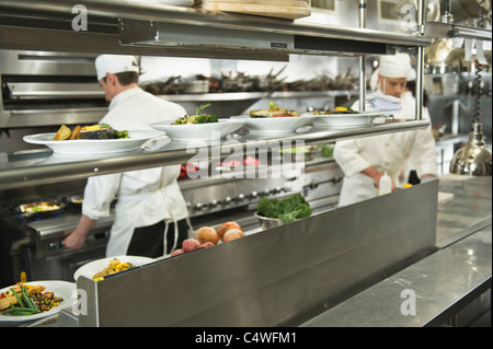 USA, New York State, New York City, Köche, die Zubereitung von Speisen in der Küche Stockfoto