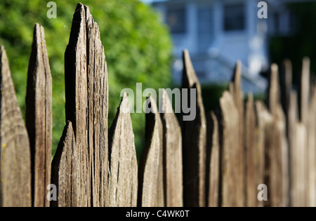 Schmale Dept Blickfeld einer schwindenden alten Holzzaun mit sehr weichem Haus im Hintergrund Stockfoto