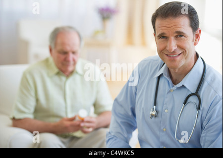 USA, New Jersey, Jersey City, Porträt von männlichen Arzt mit älteren Patienten im Hintergrund Stockfoto