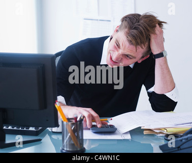 USA, New Jersey, Jersey City, Mann tut Berechnungen Kopf in Händen haltend Stockfoto