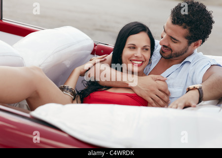 Freund und Freundin Lügen innen Cabrio Oldtimer und umarmt. Horizontale Form, Seitenansicht Stockfoto