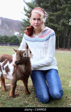 USA, New Jersey, Califon, junge Frau auf der Farm mit Zicklein Stockfoto