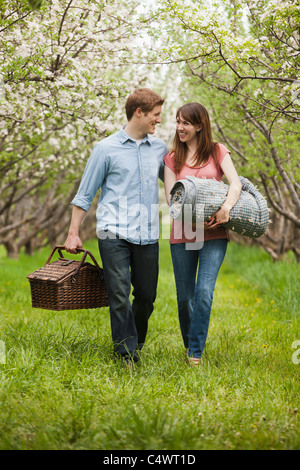 Young, Provo, Utah, USA paar mit Picknick-Korb im Obstgarten Stockfoto