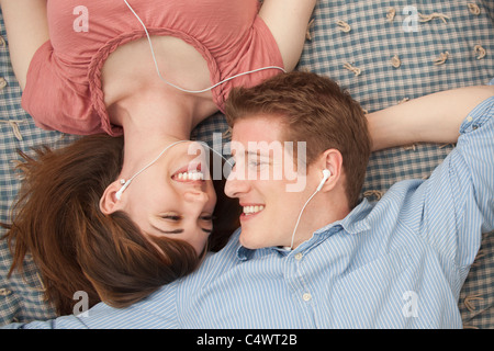 Young, Provo, Utah, USA paar mit MP3-Player auf der Decke liegend Stockfoto