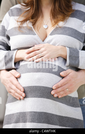 USA, California, Los Angeles, die Hände des Mannes auf schwangere Frau Bauch Stockfoto