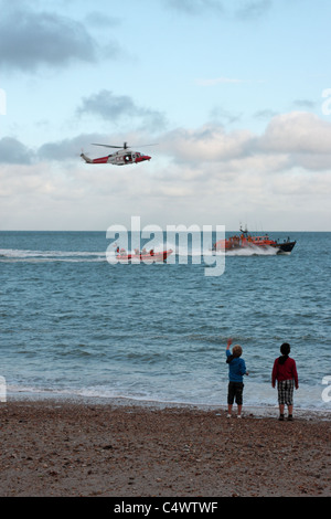 Küstenwache Hubschrauber und RNLI üben und ihre Rettung Fähigkeiten Weg Pagham Strand West Sussex UK anzeigen Stockfoto