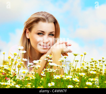 Junge schöne Mädchen, die Verlegung auf die Daisy Blumen Feld, Outdoor-Portrait, Sommerspaß Konzept Stockfoto