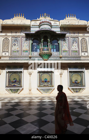 Frau zu Fuß über Hof im Stadtschloss, Udaipur, Rajasthan, Indien Stockfoto