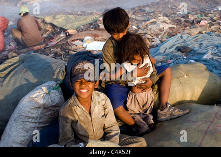 Ein junges Kind Arbeiter junge trägt einen Hut lächelt eine giftige und verschmutzten Müllhalde in Kambodscha. Stockfoto