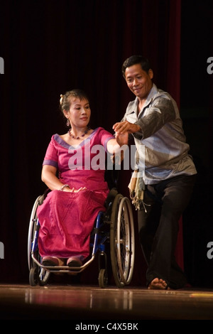 Ein tauber Mann tanzt mit einer behinderten Frau im Rollstuhl bei einer Bühnenshow in kommunistische Laos. Stockfoto