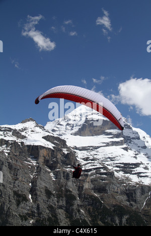 Gleitschirm in den Himmel über Gimmelwald, mit Jungfrau im Hintergrund Stockfoto