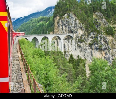 Die Rhätische Bahn von St. Moritz nach Chur ist gerade Filisur verlassen und führt über den berühmten Landwasser-Viadukt in der Schweiz Stockfoto