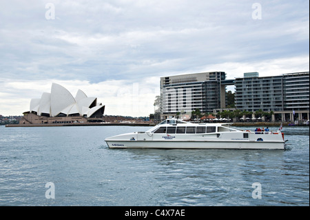 Eine kleine Fähre Abfahrt Circular Quay im Hafen von Sydney mit der Oper im Hintergrund NSW Australia Stockfoto