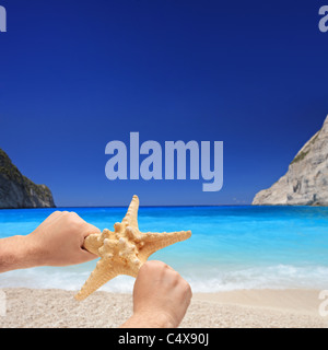 Person, die einen Seestern auf einem Sandstrand auf der Insel Zakynthos Stockfoto