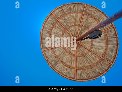 Stroh Strand Sonnenschirm, fotografiert von unten gegen den blauen Himmel, Griechenland Stockfoto