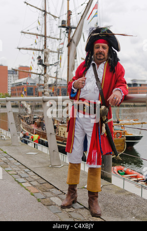 Mann verkleidet als Pirat, neben einem Großsegler Stockfoto