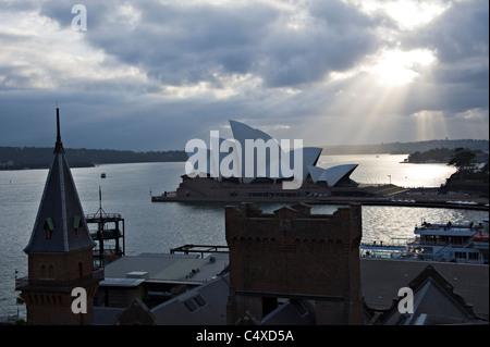 Am frühen Morgen Sonnenstrahlen durchdringen den Himmel über das Sydney Opera House am Bennelong Point NSW Australia Stockfoto