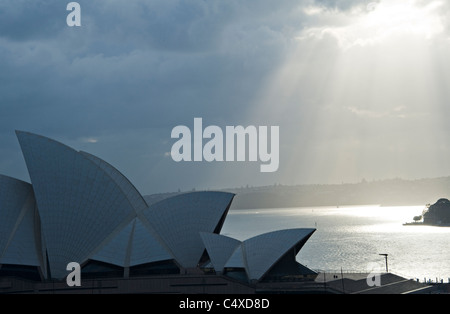 Am frühen Morgen Sonnenstrahlen durchdringen den Himmel über das Sydney Opera House am Bennelong Point NSW Australia Stockfoto