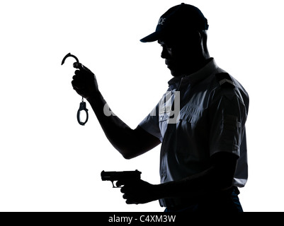 Ein Afro American Polizist mit Handschellen und Pistole im Studio auf weißen Hintergrund isoliert Stockfoto