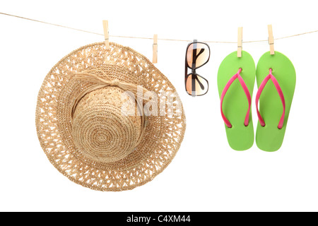 Stroh Hut, Sonnenbrille und Flip Flops an Wäscheleine hängen. Stockfoto